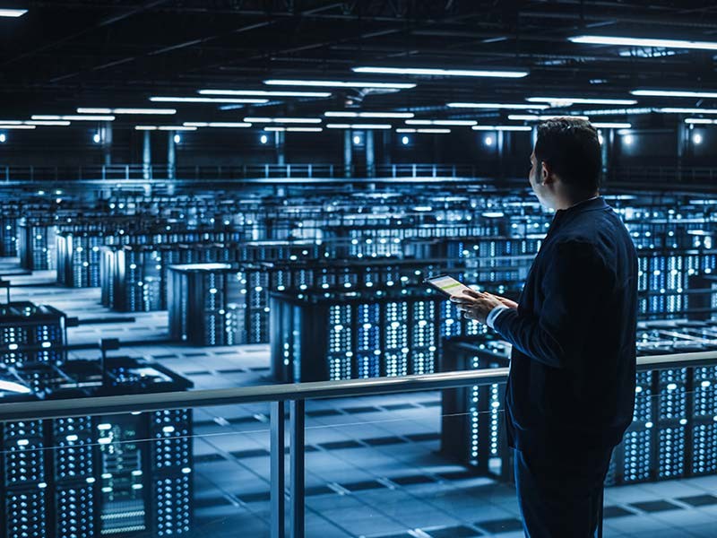 facilities manager inspects servers in data colocation center